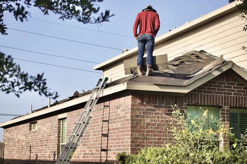 Professional roofer working on a residential roof in Fallsburg